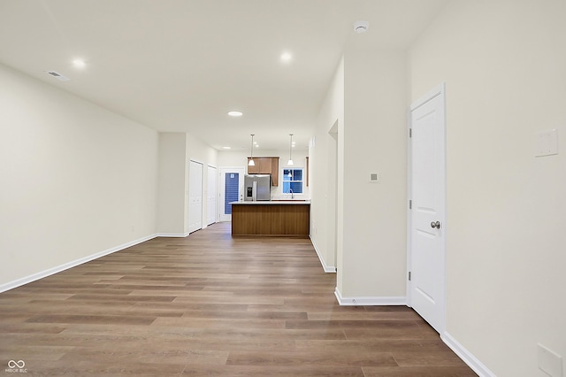 unfurnished living room featuring recessed lighting, visible vents, baseboards, and wood finished floors