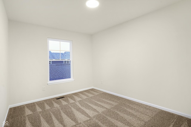 spare room featuring visible vents, baseboards, and carpet