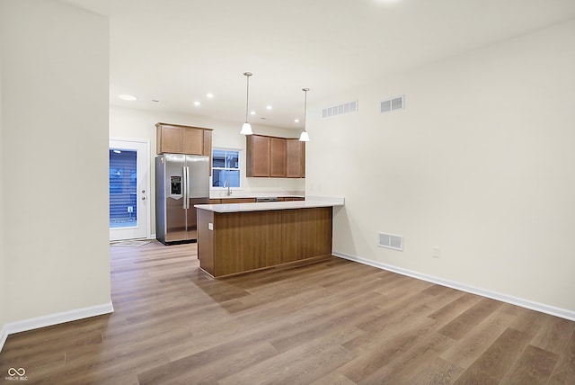 kitchen featuring visible vents, a peninsula, and stainless steel fridge with ice dispenser