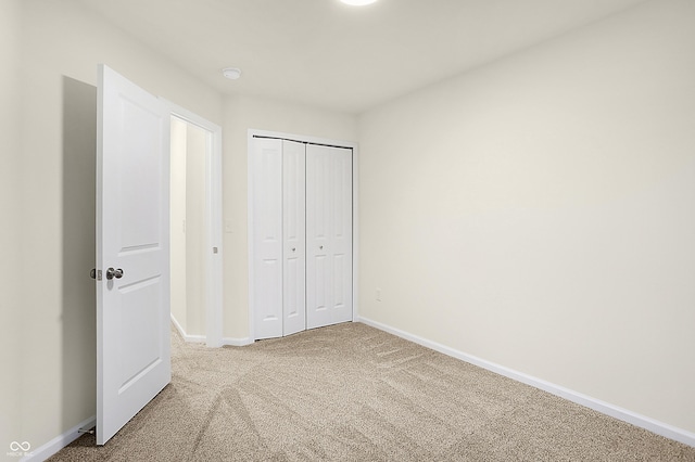 unfurnished bedroom featuring a closet, carpet flooring, and baseboards