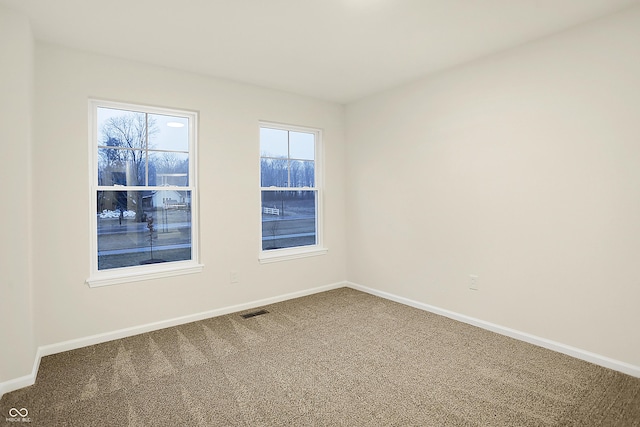 carpeted empty room with visible vents and baseboards