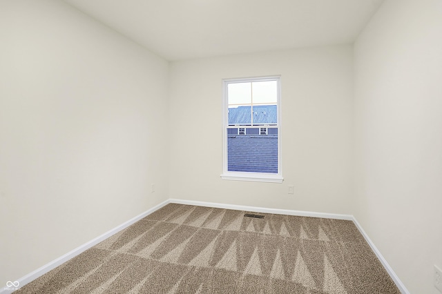 carpeted empty room featuring visible vents and baseboards