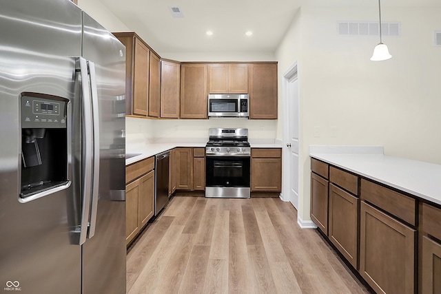 kitchen with visible vents, stainless steel appliances, light wood-type flooring, and light countertops