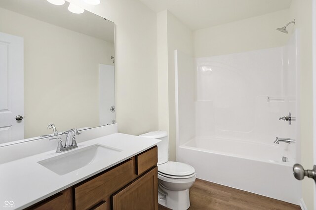 full bath featuring vanity, shower / bathing tub combination, toilet, and wood finished floors