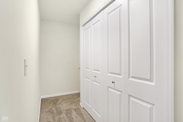 corridor with carpet flooring and baseboards