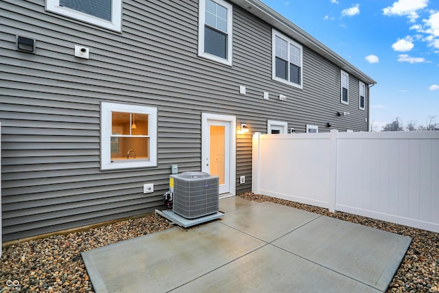 back of property featuring cooling unit, a patio, and fence