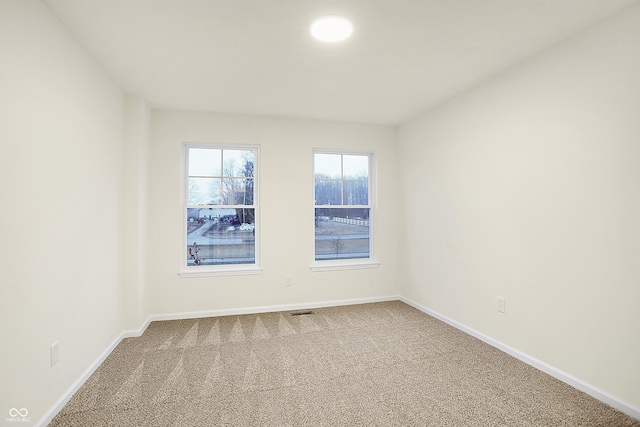 spare room featuring visible vents, baseboards, and carpet