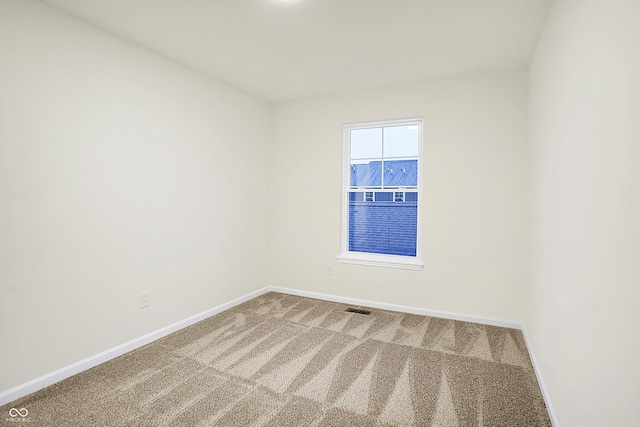 carpeted empty room with visible vents and baseboards