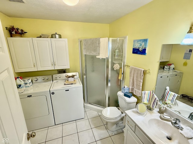 full bath with washer and clothes dryer, vanity, a shower stall, a textured ceiling, and tile patterned flooring