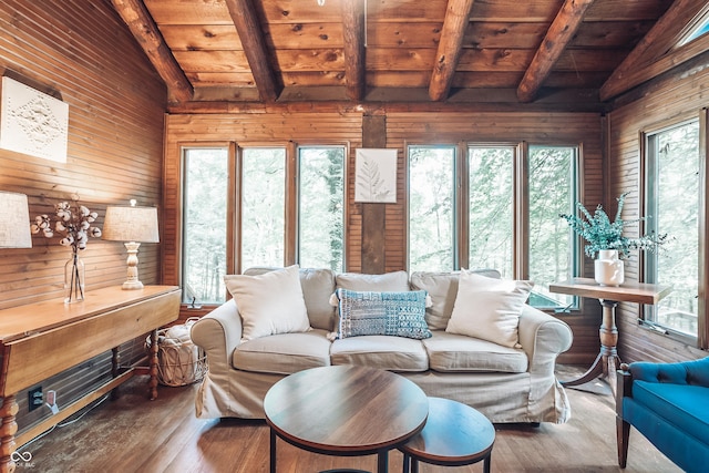 living area with lofted ceiling with beams, wooden walls, wood ceiling, and wood finished floors