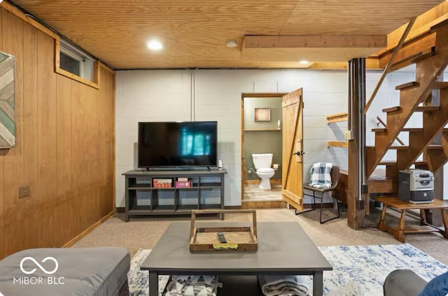 living room featuring light carpet, wood walls, wood ceiling, and stairs