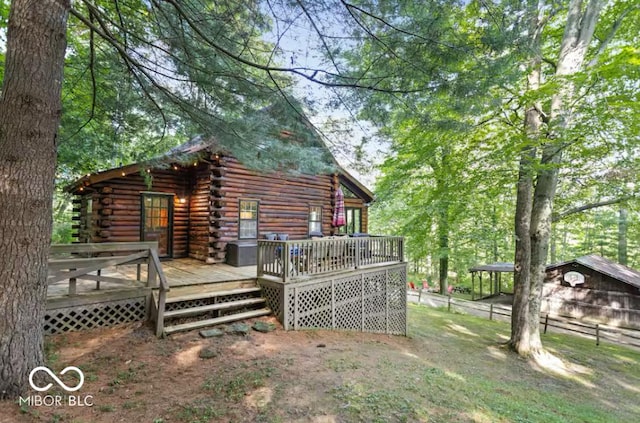 back of house featuring log siding and a deck