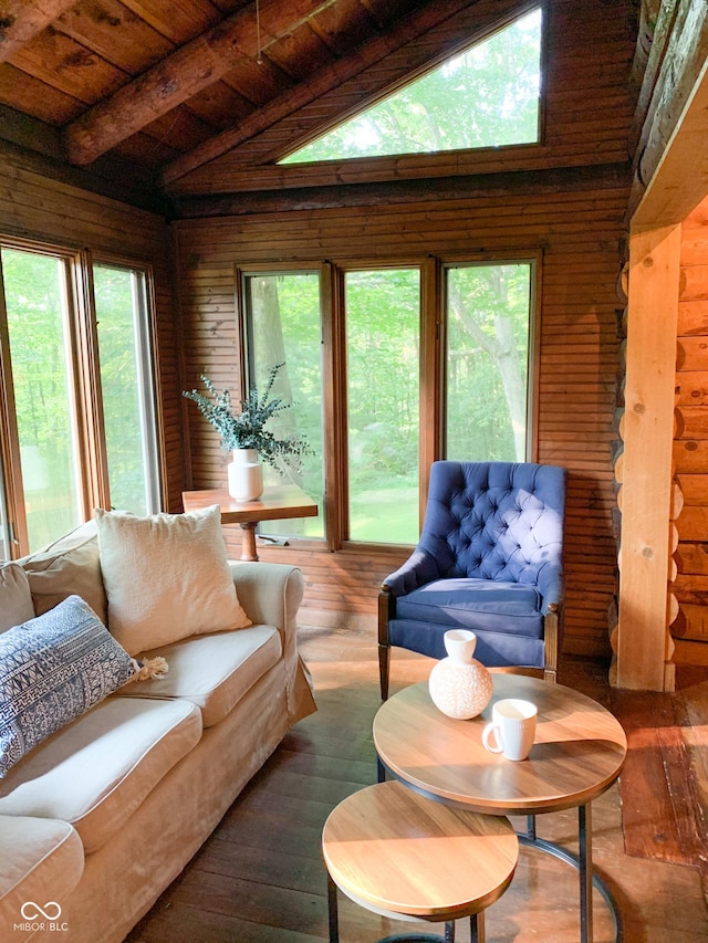 living area featuring log walls, plenty of natural light, hardwood / wood-style floors, and vaulted ceiling with beams