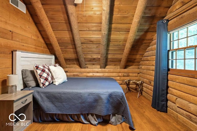 bedroom with rustic walls, wood ceiling, lofted ceiling with beams, and wood finished floors