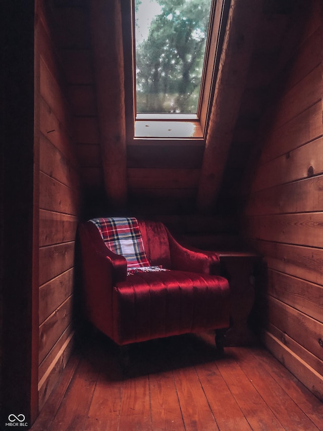 living area featuring wood walls and hardwood / wood-style floors