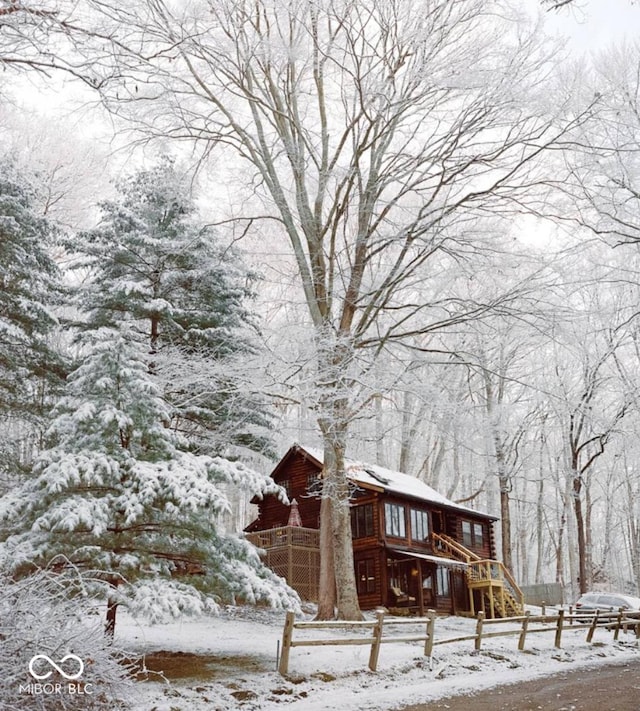 view of snow covered exterior with fence