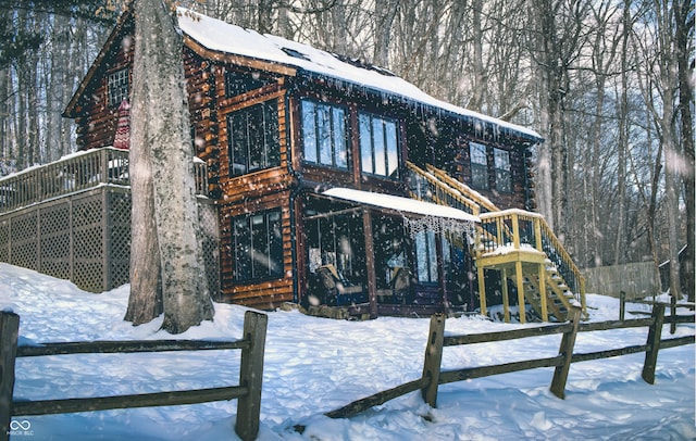 view of snowy exterior with log exterior