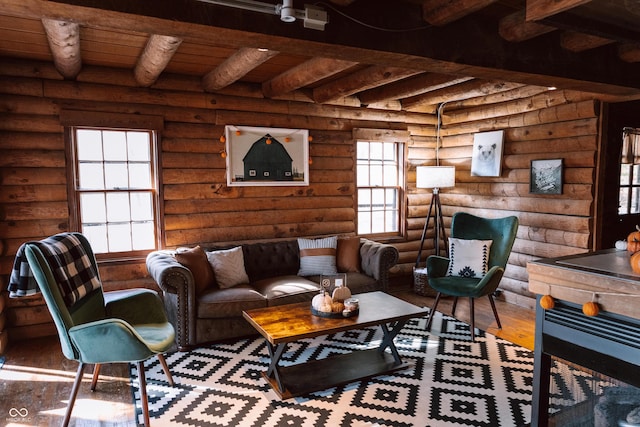 living area featuring beam ceiling, rustic walls, and wood finished floors