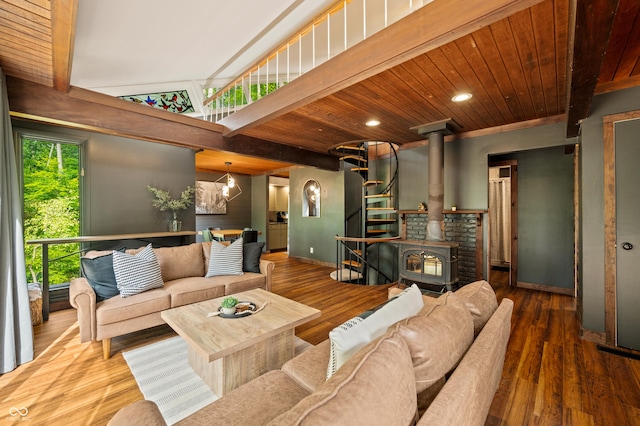 living room with wood finished floors, baseboards, beam ceiling, a wood stove, and wood ceiling