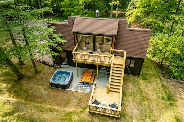 rear view of house featuring a wooden deck and roof with shingles