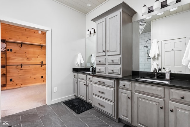 full bath featuring double vanity, baseboards, and a sink