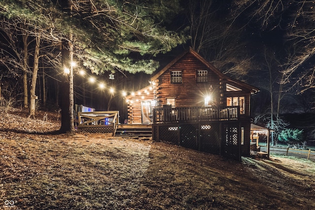 property exterior at twilight with a deck and log exterior