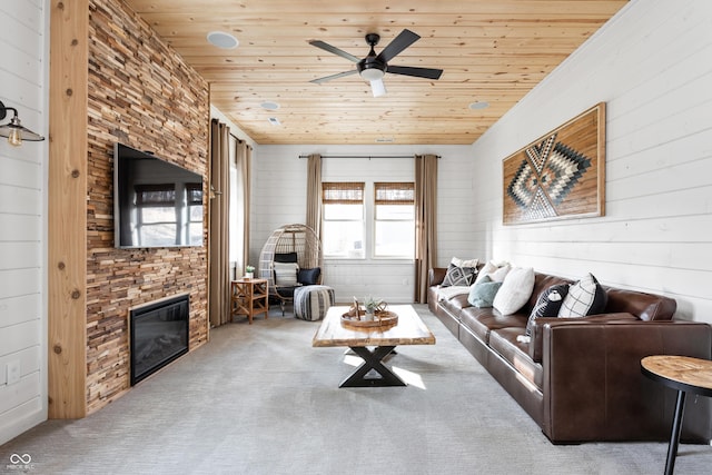 living area featuring wooden ceiling, a fireplace, ceiling fan, and carpet floors