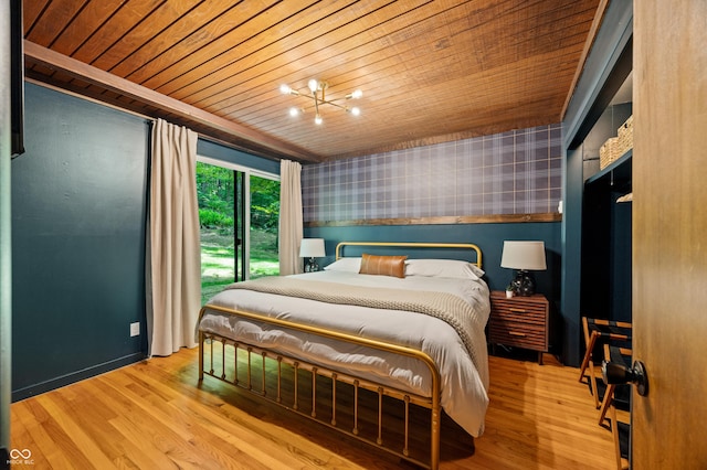 bedroom with a chandelier, wood ceiling, wood finished floors, and wallpapered walls