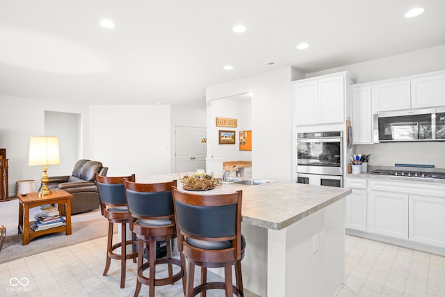 936 Plunkett Ave, Westfield, IN 46074 - kitchen featuring stainless steel appliances, a kitchen island with sink, light countertops, recessed lighting, and white cabinets