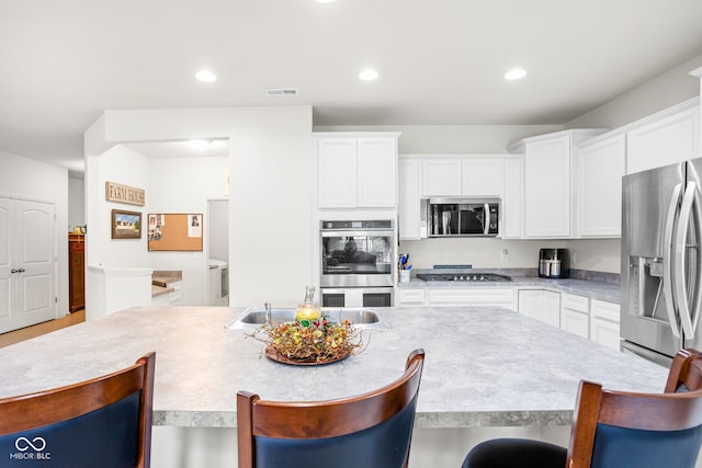 936 Plunkett Ave, Westfield, IN 46074 - kitchen featuring appliances with stainless steel finishes, a kitchen bar, white cabinets, light countertops, and recessed lighting