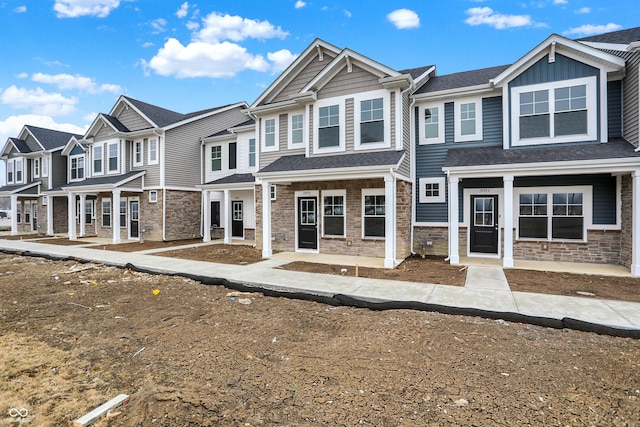 multi unit property with board and batten siding, a residential view, and stone siding