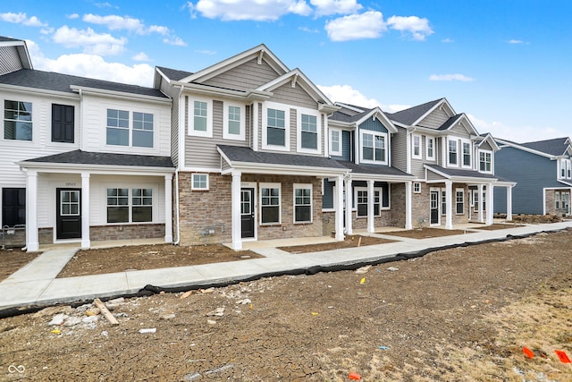 multi unit property with a residential view, a porch, and stone siding