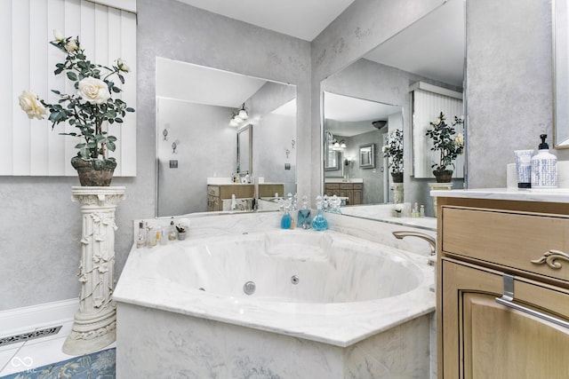 full bath with visible vents, vanity, and a whirlpool tub