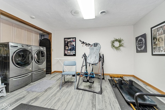 laundry room featuring visible vents, baseboards, washer and dryer, cabinet space, and a textured ceiling