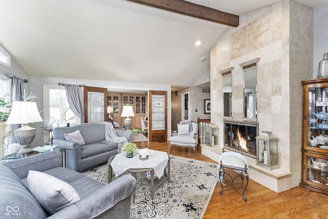 living room with beamed ceiling, high vaulted ceiling, wood finished floors, and a fireplace