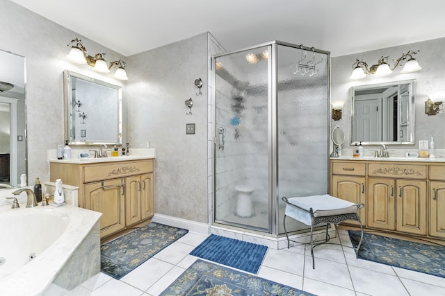 full bath with tile patterned flooring, a tub with jets, a shower stall, and a sink