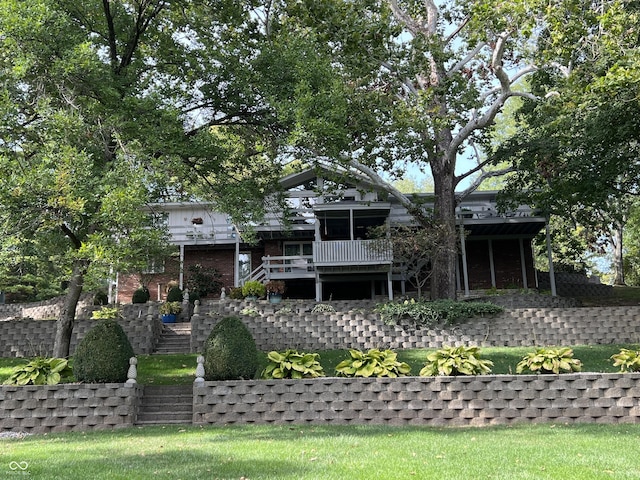 back of house featuring brick siding, stairway, and a yard