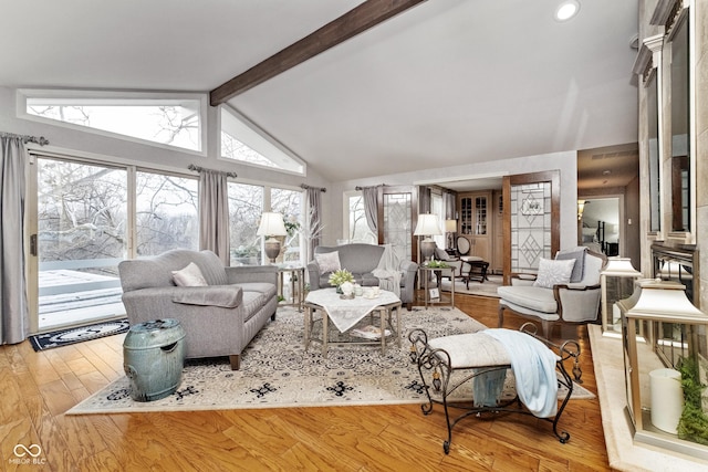 living area with hardwood / wood-style floors and vaulted ceiling with beams