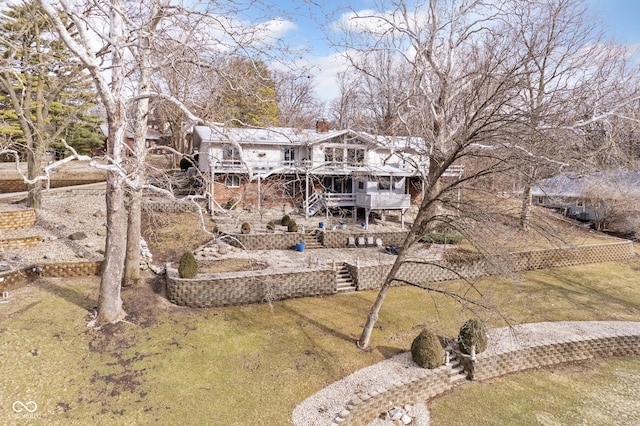 rear view of property featuring a deck, stairway, and a yard