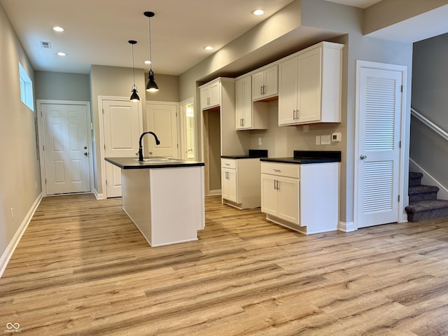 924 N Oakland Ave, Indianapolis, IN 46201 - kitchen featuring a sink, dark countertops, light wood-type flooring, white cabinetry, and recessed lighting