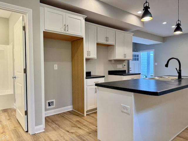 924 N Oakland Ave, Indianapolis, IN 46201 - kitchen with a sink, dark countertops, light wood finished floors, white cabinetry, and pendant lighting