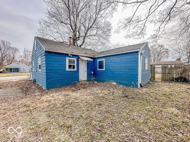 rear view of house with fence and a chimney