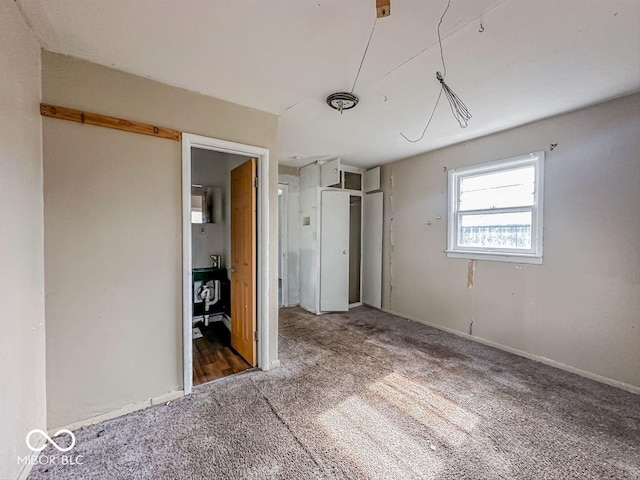 unfurnished bedroom featuring carpet, baseboards, and a closet