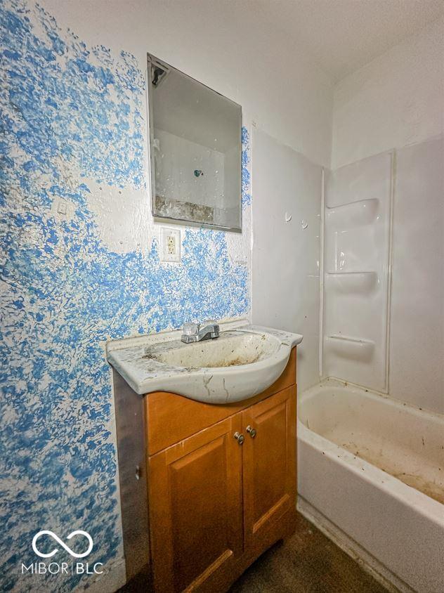 full bathroom with shower / washtub combination and vanity