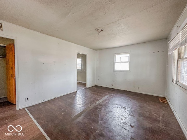 unfurnished room with visible vents, baseboards, and a textured ceiling