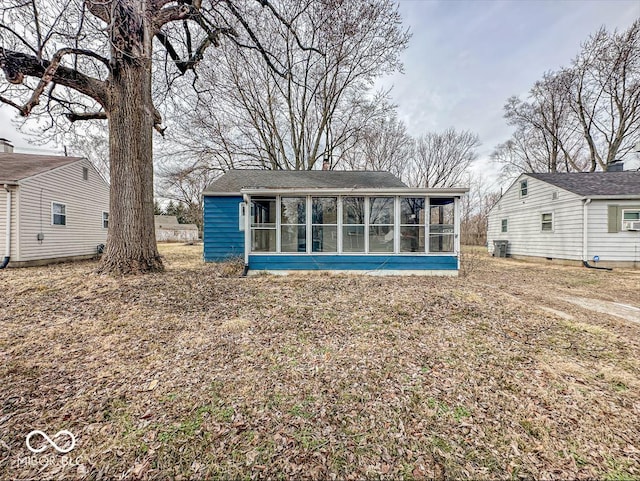 back of property featuring a sunroom, a chimney, and central AC unit