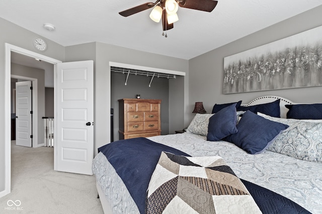 carpeted bedroom featuring a closet and ceiling fan