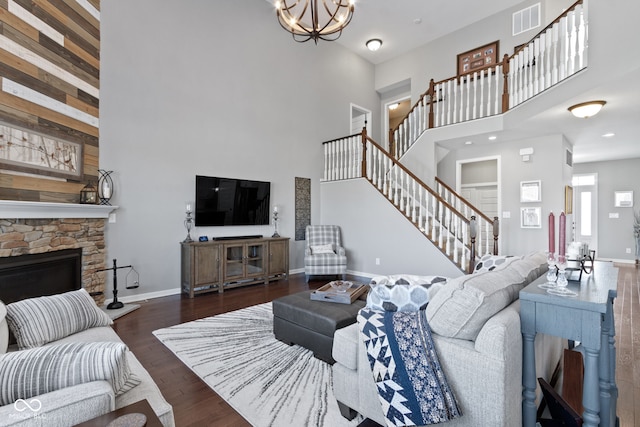 living area featuring visible vents, baseboards, stairs, a towering ceiling, and dark wood-style floors