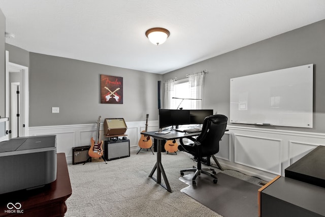 carpeted office space with a wainscoted wall