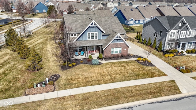 view of front of property with a residential view, a porch, a front yard, and board and batten siding